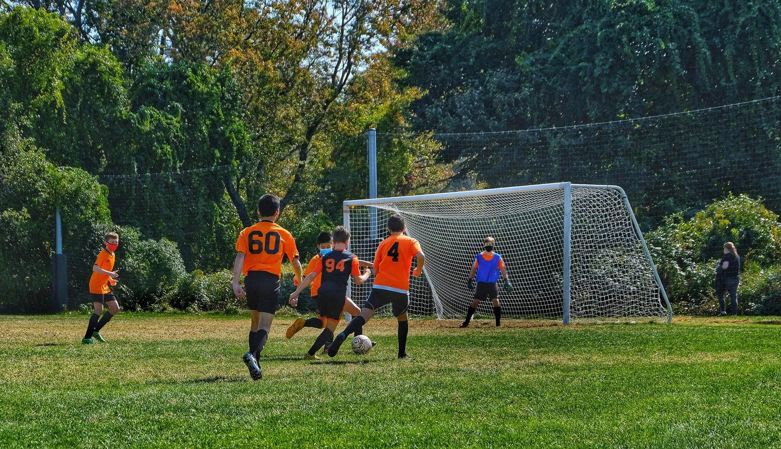 group of children playing soccer on green grass field during daytime